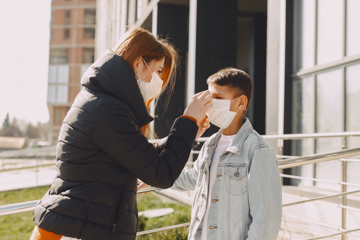 Woman Fixing Mask For Child